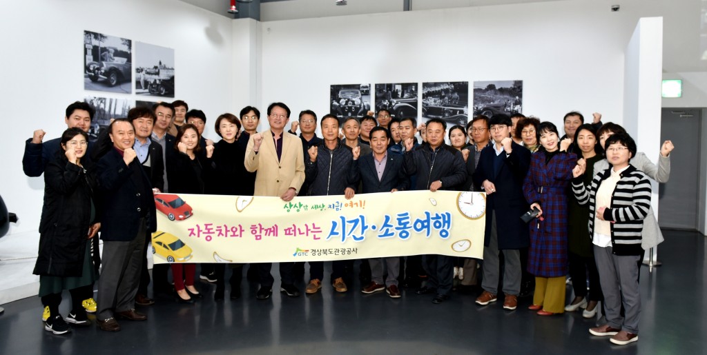 자동차 박물관에서 단체기념 촬영을 하고 있다