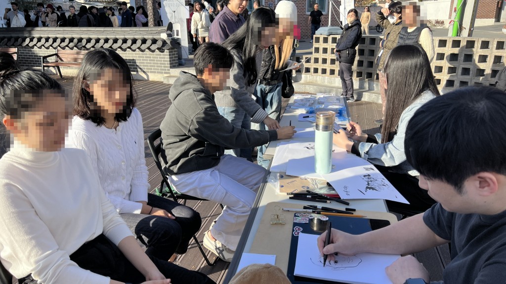 4-2. 22일 웹툰 작가들이 방문객들의 얼굴을 묘사해 캐리커처를 그리고 있다.